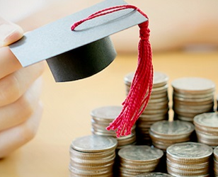 Graduation cap near stacks of coins.